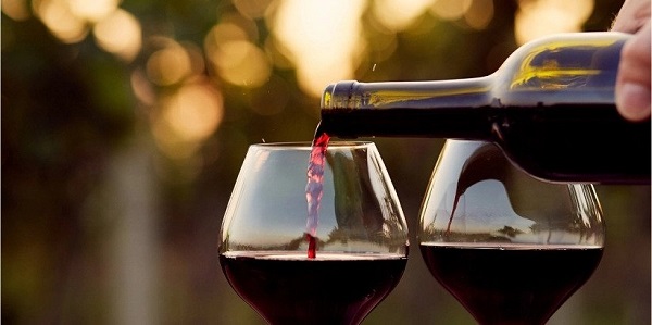 Red Wine being poured into a glass from a bottle.