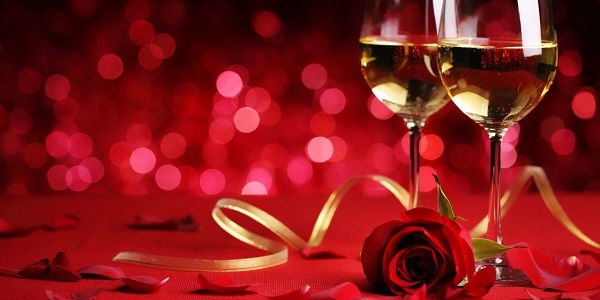 Image of Champagne glasse yellow ribbon red rose petals wine.