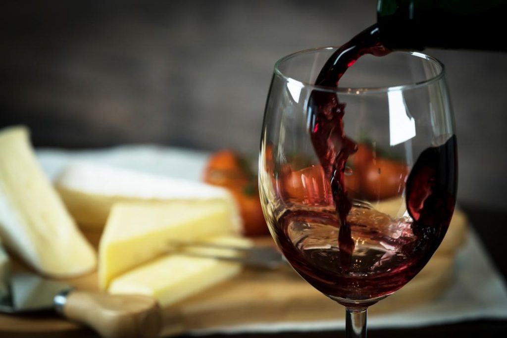 Pouring Red wine into the Glass against blur background