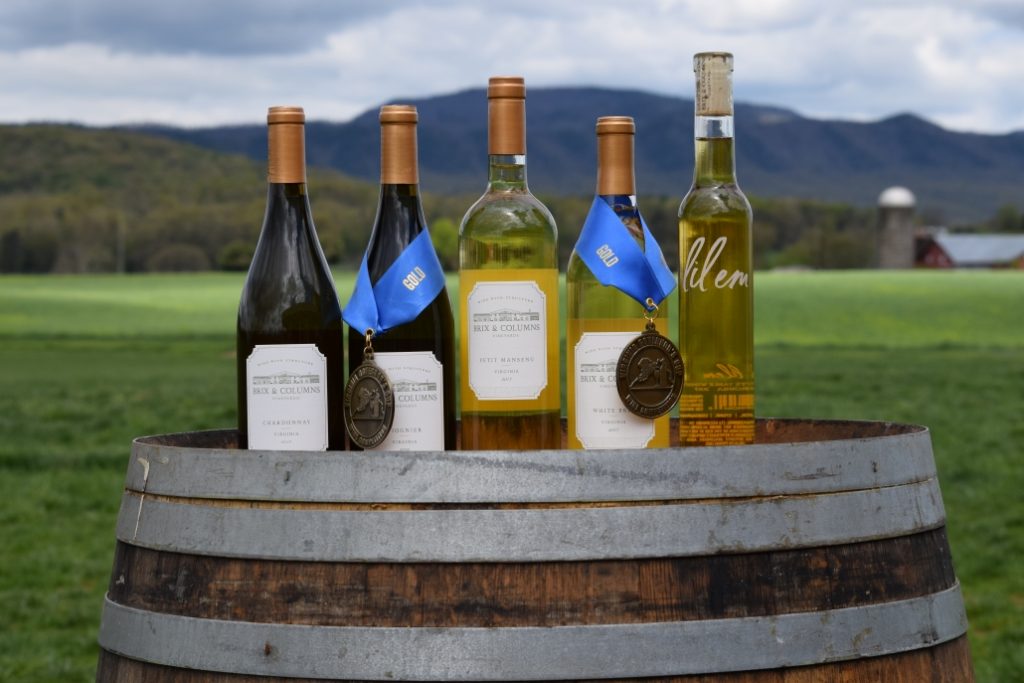 An Image of Five Bottles Placed On a Drum In a Nature Background